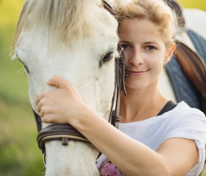 Beautiful young blonde woman portrait with her horse